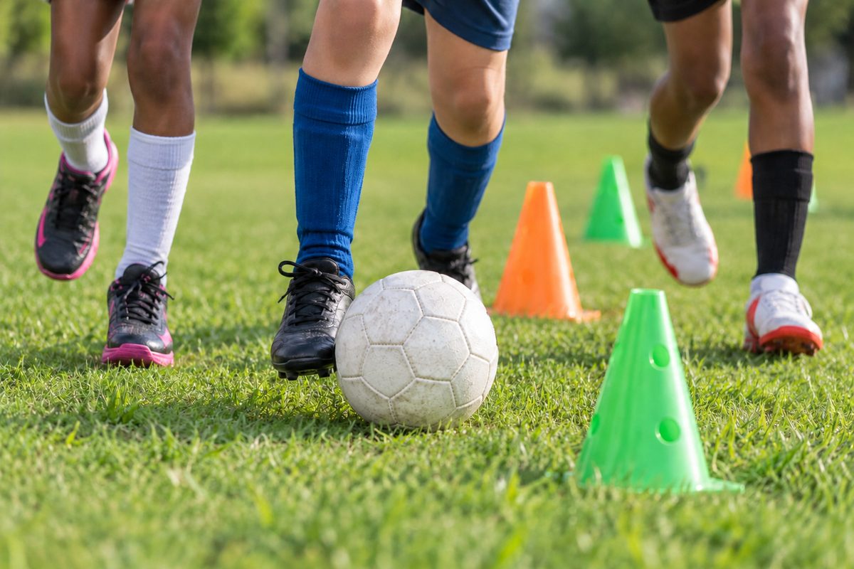 A football being played between training cones on a playing field